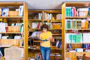 Photo gratuite apprendre la femme debout entre les bibliothèques