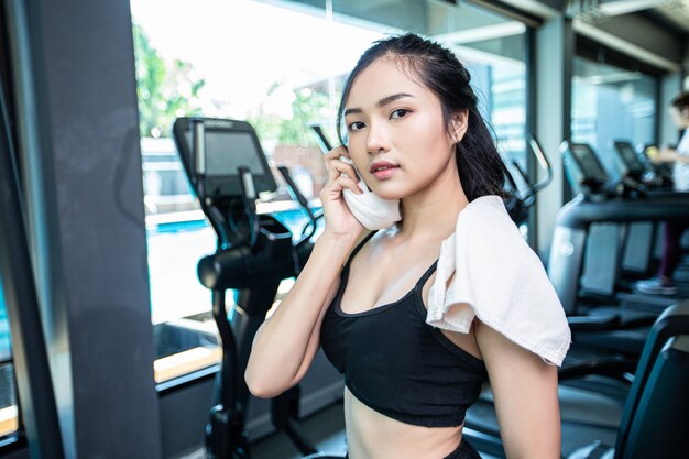 Après l’exercice, les femmes essuient le visage avec un chiffon blanc dans la salle de sport.