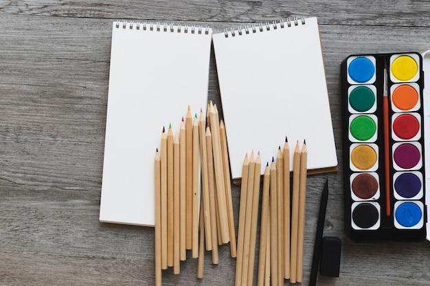 Aquarelle et crayons près des carnets de croquis