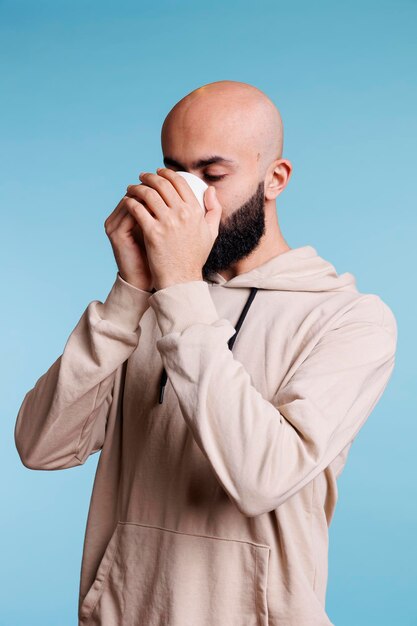 Photo gratuite un arabe buvant du café avec une tasse.