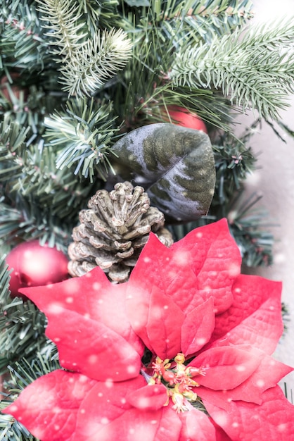 arbre de Noël avec des pommes de pin et une fleur rouge