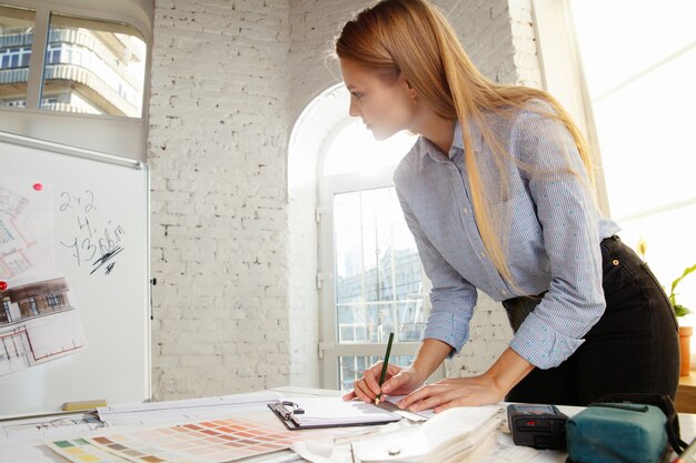 Architecte d'intérieur professionnel ou architecte travaillant avec une palette de couleurs, des dessins de pièce dans un bureau moderne.