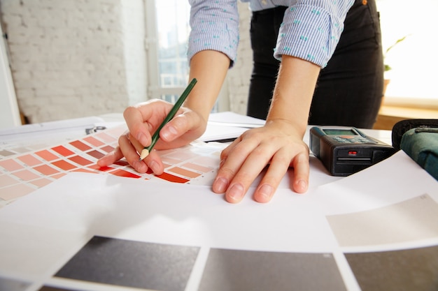 Architecte d'intérieur professionnel ou architecte travaillant avec une palette de couleurs, des dessins de pièce dans un bureau moderne.