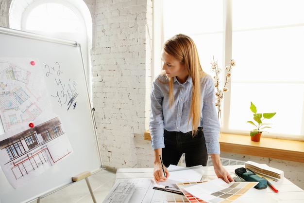 Architecte d'intérieur professionnel ou architecte travaillant avec une palette de couleurs, des dessins de pièce dans un bureau moderne