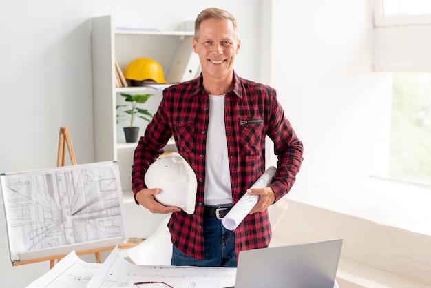 Architecte souriant en posant au bureau