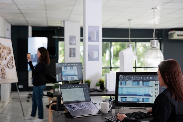 Architecte travaillant dans un logiciel de modélisation 3d, modèle de bâtiment multi-magasins sur écran d'ordinateur. Employé de bureau d'architecture travaillant dans un espace de coworking, outils d'agence immobilière, projets de plan.