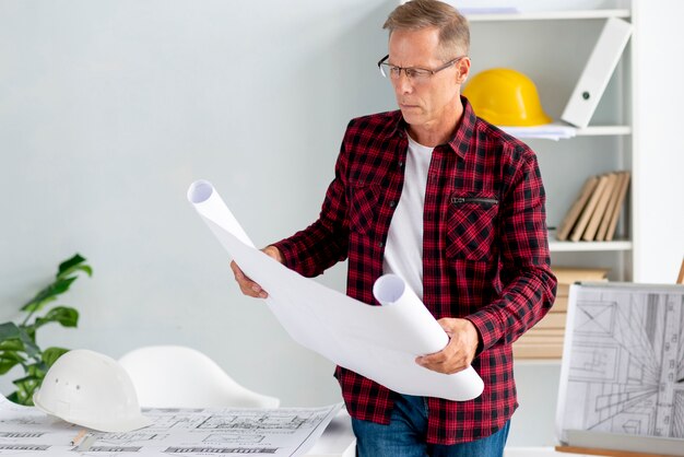 Architecte vérifiant le projet dans le bureau