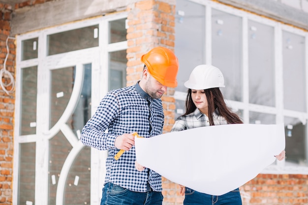 Architectes regardant plan devant la maison