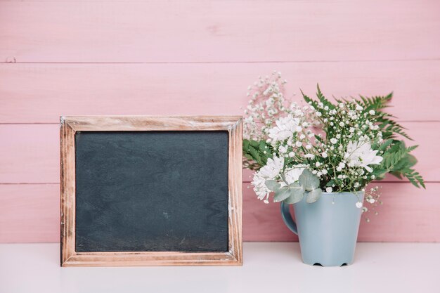 Ardoise à côté du pot de fleurs