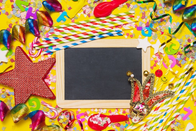 ardoise noire avec la décoration de fête, bouclettes et une étoile rouge