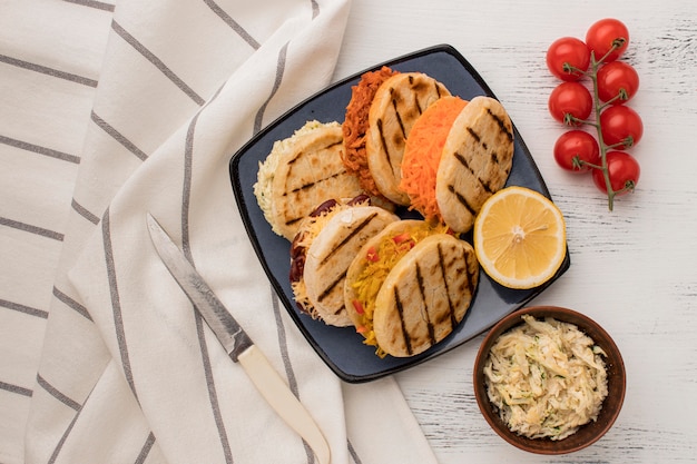 Photo gratuite arepas à plat sur assiette avec des tomates