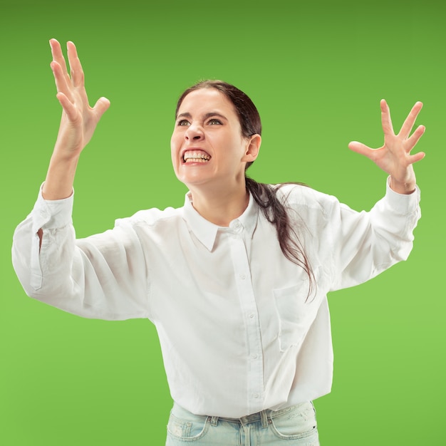 Argumenter, argumenter le concept. Beau portrait de femme demi-longueur isolé sur fond de studio vert.