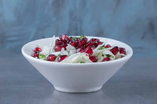 Photo gratuite arilles de grenade et légumes râpés, sur la surface du marbre.