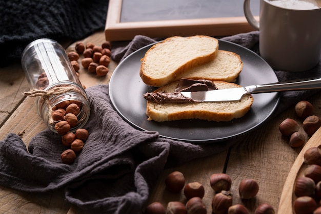 Photo gratuite arrangement à angle élevé avec du pain et des noisettes