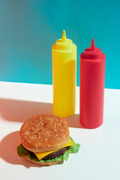 Photo gratuite arrangement à angle élevé avec des hamburgers et des bouteilles de sauce