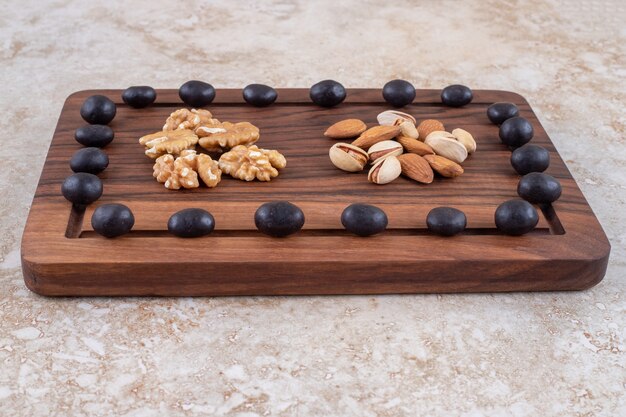 Un arrangement de bonbons au chocolat et de piles de noix sur une planche