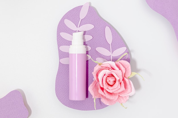 Arrangement de bouteille de maquillage violet avec rose rose