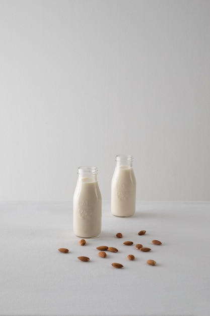 Photo gratuite arrangement de bouteilles de lait et d'amandes à angle élevé