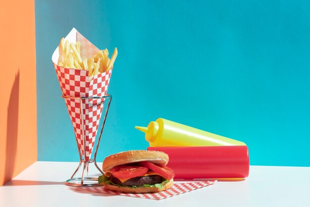 Arrangement avec des bouteilles de sauce et un hamburger