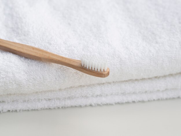 Arrangement avec brosse à dents en bois et serviettes