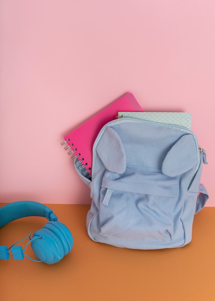 Photo gratuit arrangement de bureau avec sac à dos et écouteurs