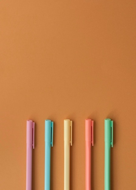 Arrangement de bureau vue de dessus avec des stylos colorés