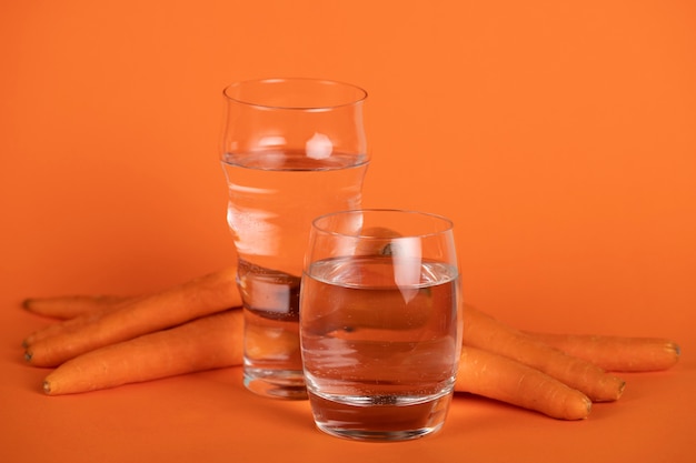 Arrangement avec des carottes et des verres d'eau