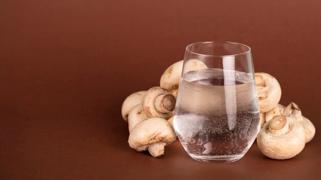 Arrangement avec des champignons et un verre d'eau