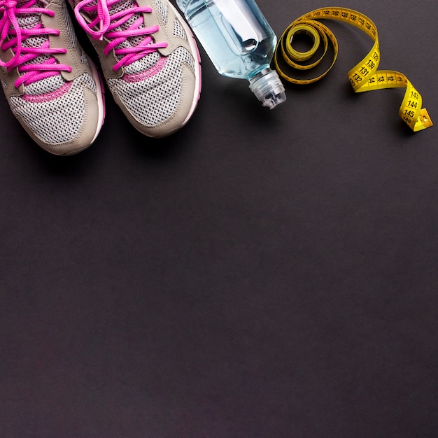 Arrangement avec des chaussures de course et une bouteille d'eau