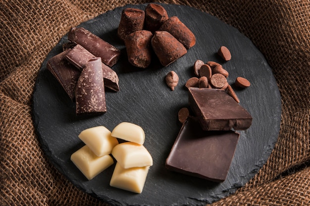 Arrangement de chocolat sucré à angle élevé sur tableau noir