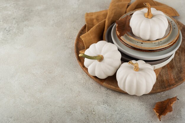 Arrangement avec des citrouilles blanches et des assiettes à angle élevé