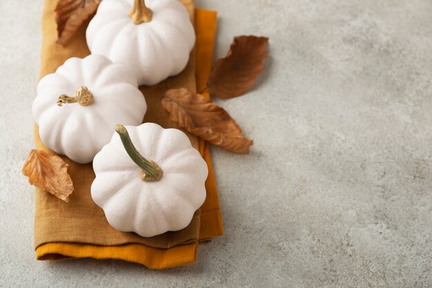 Photo gratuite arrangement de citrouilles et de chiffons blancs à angle élevé