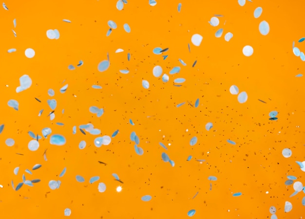 Arrangement de confettis de fête sur mur orange