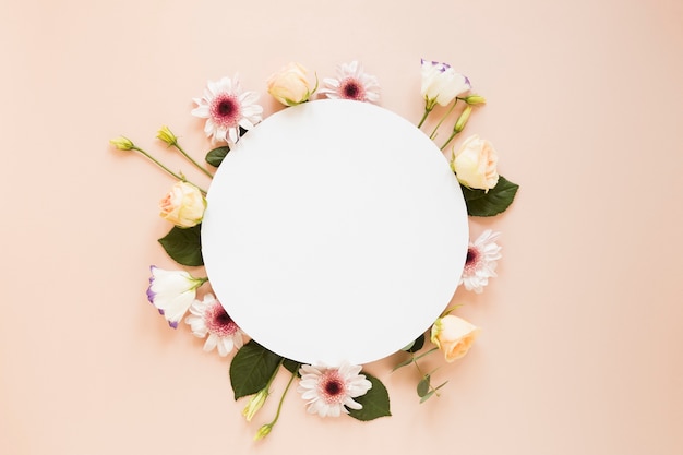 Arrangement de diverses fleurs de printemps et morceau de papier rond vide