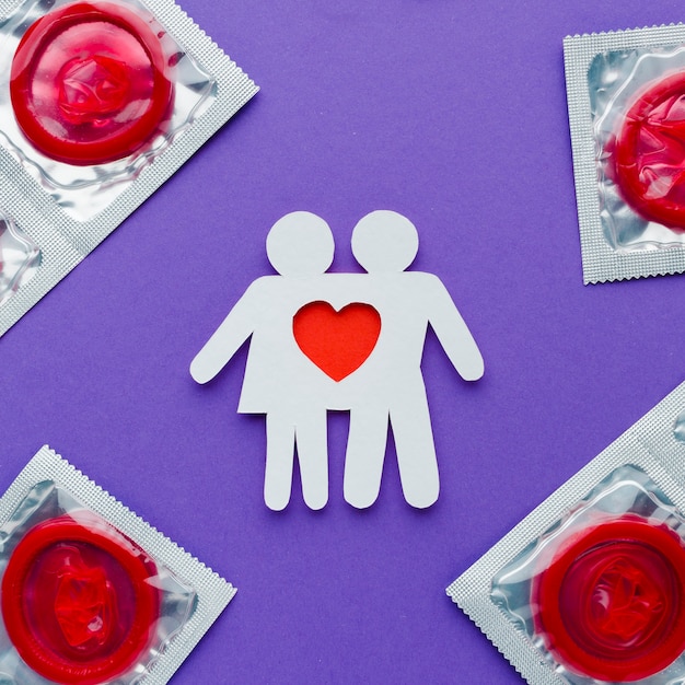 Arrangement du concept de contraception avec préservatifs rouges et couple de papier