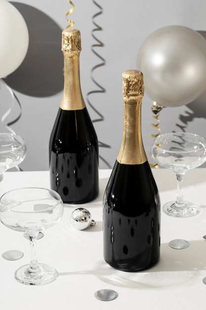 Photo gratuite arrangement de fête du nouvel an avec bouteille de champagne