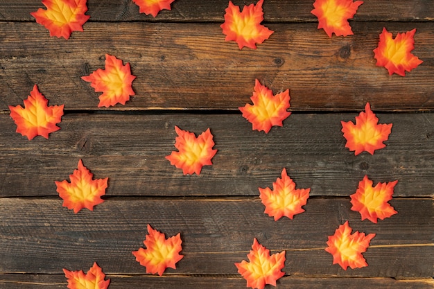 Arrangement de feuilles orange sur fond en bois