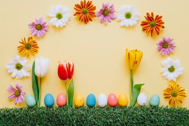 Arrangement de fleurs aux couleurs vives et oeufs colorés