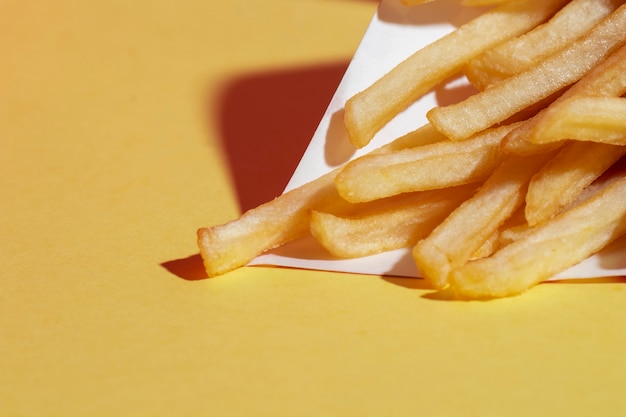 Arrangement grand angle avec des pommes de terre frites sur fond jaune