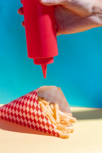 Arrangement gros plan avec personne versant du ketchup