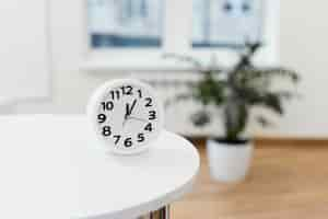 Photo gratuite arrangement avec horloge sur table