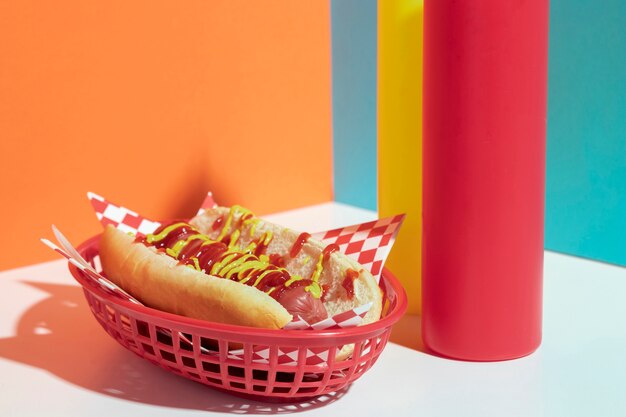 Arrangement avec hot-dog dans des paniers et des bouteilles de sauce