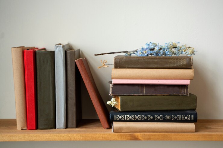 Photo gratuit arrangement de livres sur étagère avec fleur