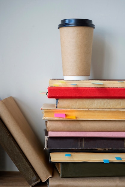 Photo gratuite arrangement de livres sur étagère avec tasse