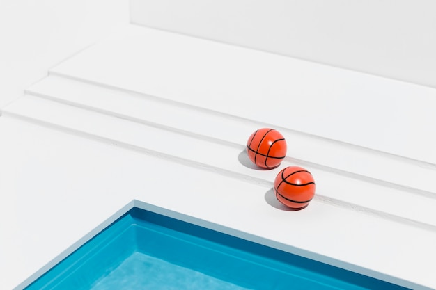 Arrangement de nature morte piscine miniature avec des ballons de basket