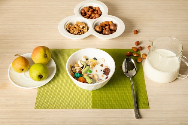 Arrangement de petit déjeuner fruits, noix et céréales sur fond Uni