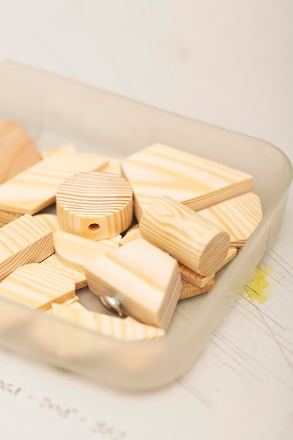 Arrangement de pièces en bois dans une boîte en plastique