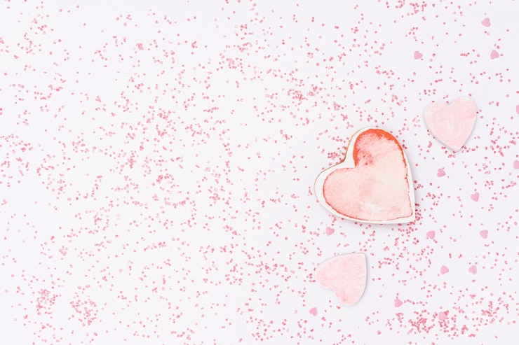 Photo gratuit arrangement plat avec fond en forme de coeur rose et rose