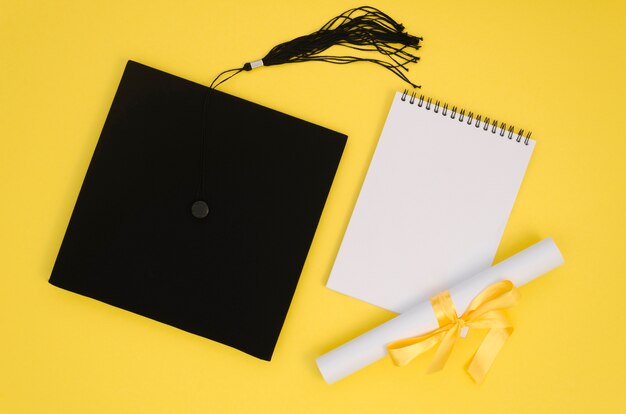 Arrangement de remise des diplômes festif plat avec bloc-notes vide