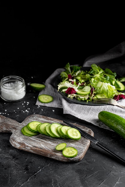 Arrangement de salade à angle élevé avec vaisselle sombre